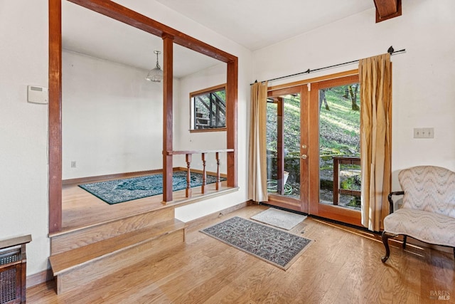 doorway to outside with french doors, baseboards, and wood finished floors