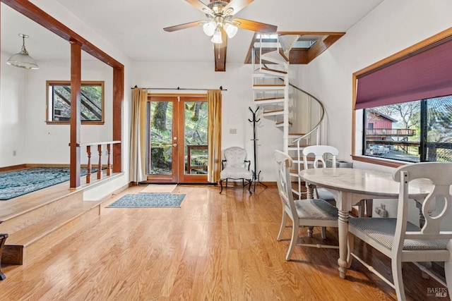 dining area with a ceiling fan, wood finished floors, stairway, french doors, and baseboards