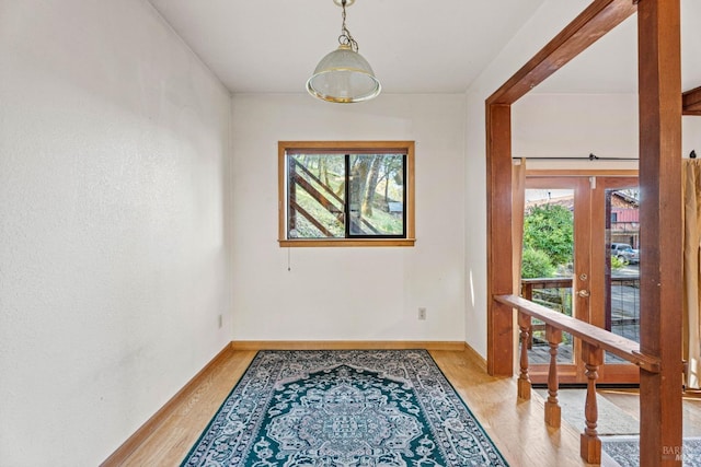 interior space with a wealth of natural light, baseboards, and light wood finished floors