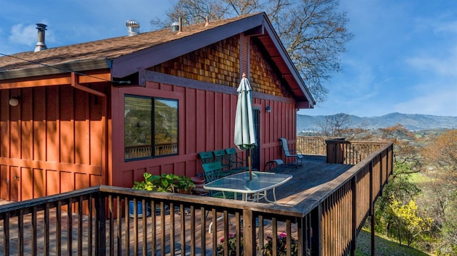 wooden deck featuring outdoor dining space and a mountain view