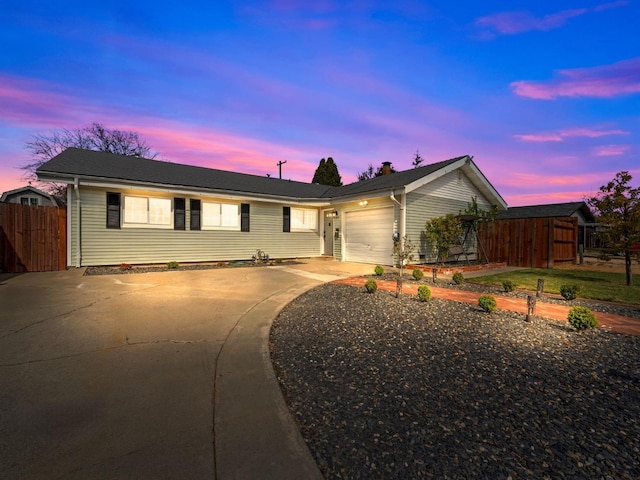 ranch-style house featuring driveway, a garage, and fence