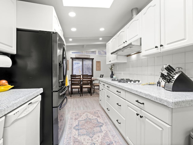 kitchen with under cabinet range hood, white cabinetry, recessed lighting, white appliances, and decorative backsplash