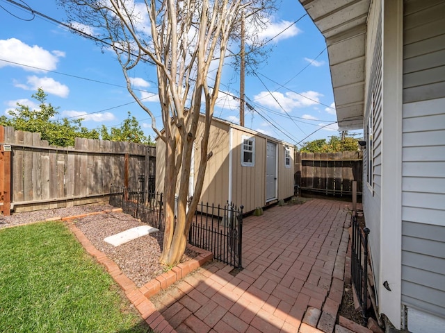 exterior space featuring a patio, a storage unit, a fenced backyard, and an outbuilding