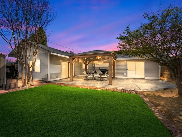 rear view of house featuring a gazebo, a patio, a lawn, and fence