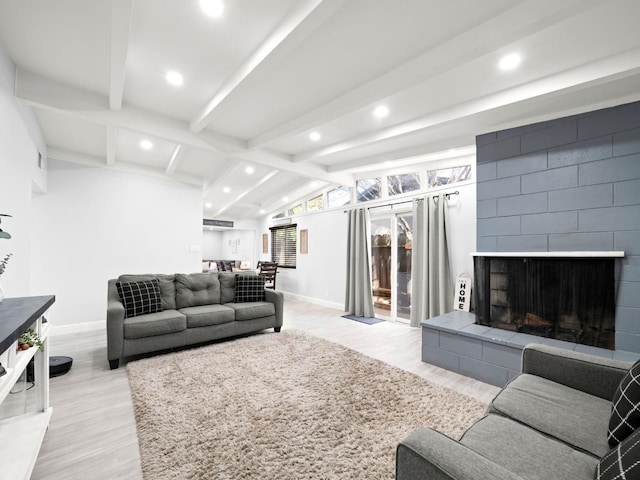 living area featuring baseboards, lofted ceiling with beams, light wood-type flooring, recessed lighting, and a fireplace