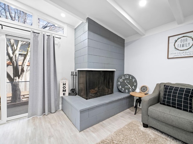 living room featuring wood finished floors, beamed ceiling, recessed lighting, and a fireplace