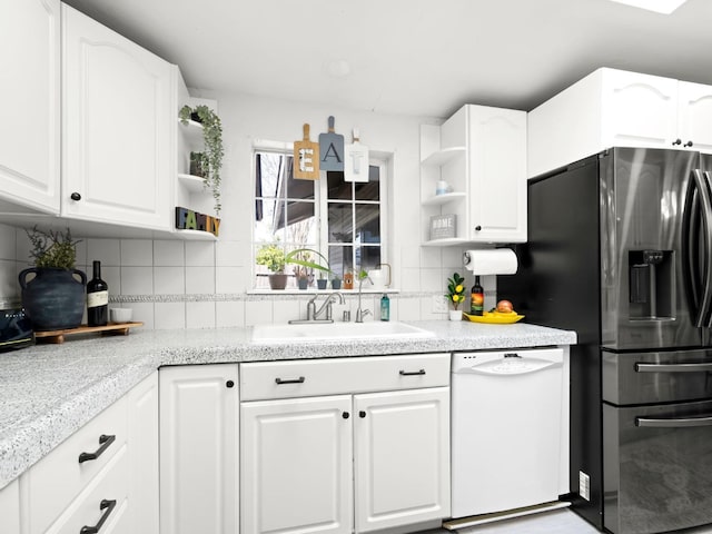 kitchen with stainless steel refrigerator with ice dispenser, open shelves, a sink, tasteful backsplash, and white dishwasher