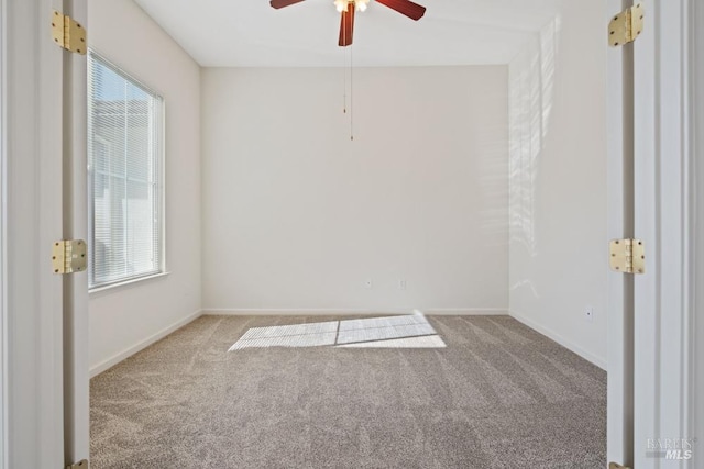 carpeted spare room with baseboards and a ceiling fan