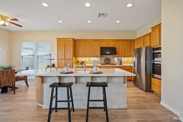 kitchen featuring a ceiling fan, visible vents, under cabinet range hood, light countertops, and stainless steel appliances