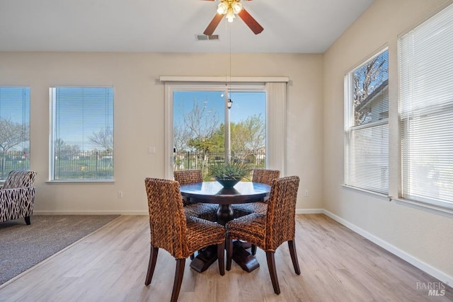 dining space with visible vents, ceiling fan, baseboards, and light wood-style flooring