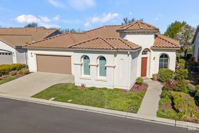 mediterranean / spanish-style house with stucco siding, concrete driveway, a front lawn, a garage, and a tile roof