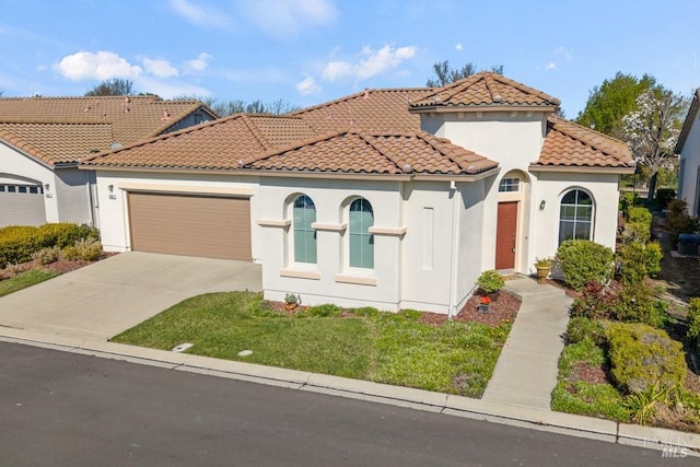 mediterranean / spanish house featuring stucco siding, a front yard, a tile roof, a garage, and concrete driveway