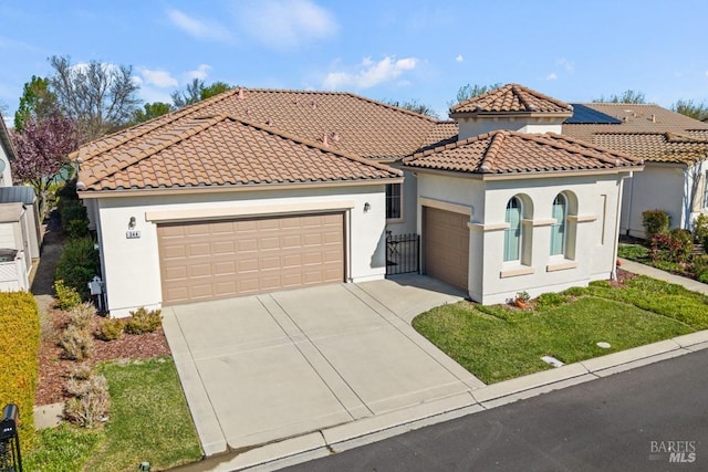 mediterranean / spanish-style home featuring a tile roof, driveway, and stucco siding