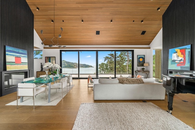 living room with wood finished floors, wood ceiling, a water view, and high vaulted ceiling