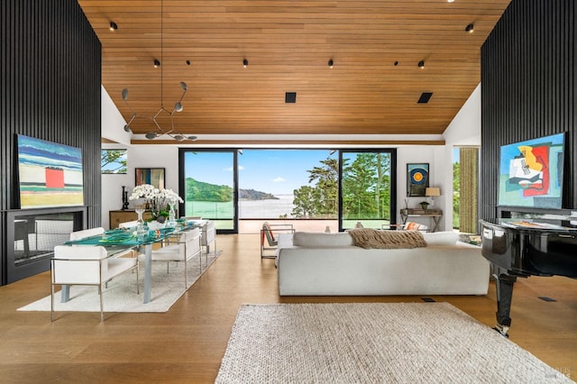 living area with high vaulted ceiling, wood finished floors, and wooden ceiling