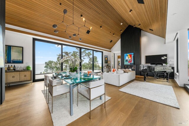 living room featuring wooden ceiling, a dry bar, light wood-style floors, and high vaulted ceiling
