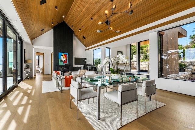 dining space featuring wood ceiling, a notable chandelier, wood finished floors, and high vaulted ceiling