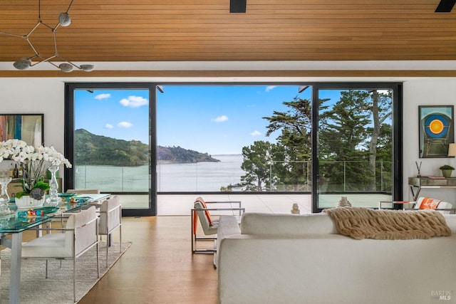 living area with wood finished floors, a water view, and wooden ceiling