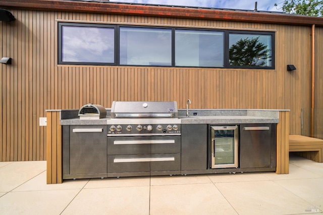 view of patio / terrace with a sink, exterior kitchen, beverage cooler, and grilling area