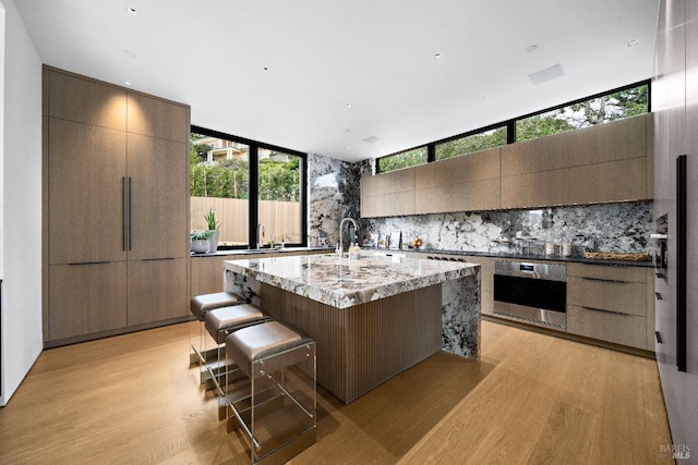 kitchen with tasteful backsplash, modern cabinets, and oven