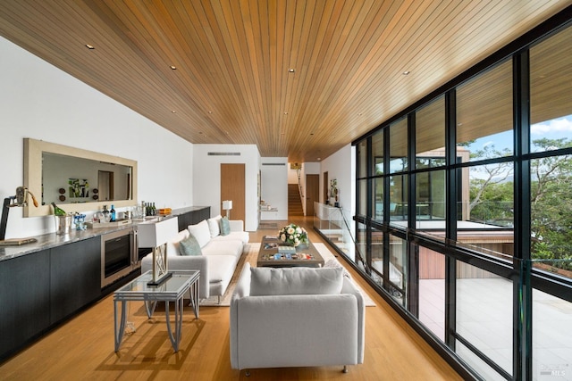 living room with visible vents, floor to ceiling windows, wine cooler, wood ceiling, and light wood-type flooring