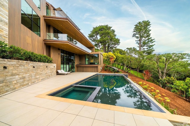 view of swimming pool featuring a patio area and a pool with connected hot tub