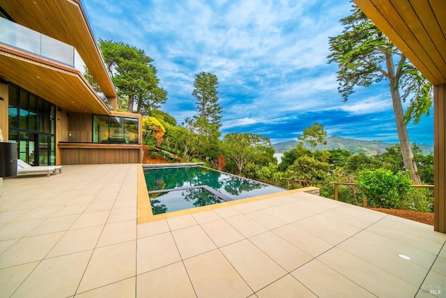 view of pool featuring a patio and a mountain view