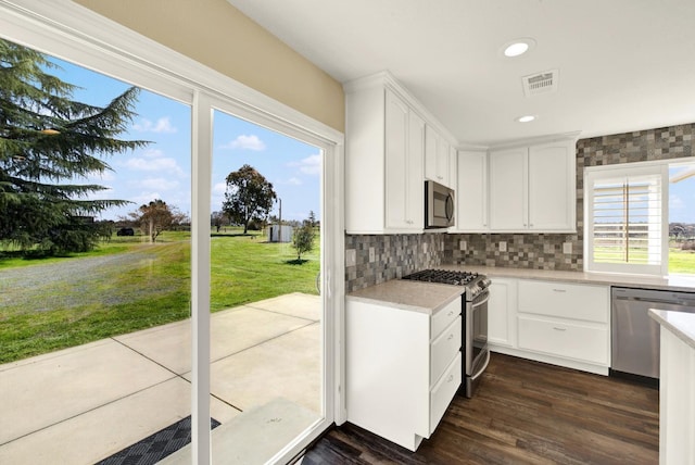 9862 Whalen Rd, Wallace, CA 95252 - kitchen featuring appliances with stainless steel finishes, backsplash, white cabinetry, light countertops, and dark wood-style floors