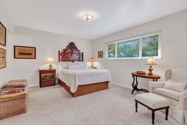 bedroom featuring light colored carpet and baseboards