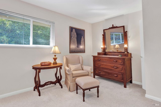 living area featuring baseboards and light carpet