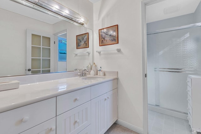 bathroom featuring baseboards, a stall shower, and vanity