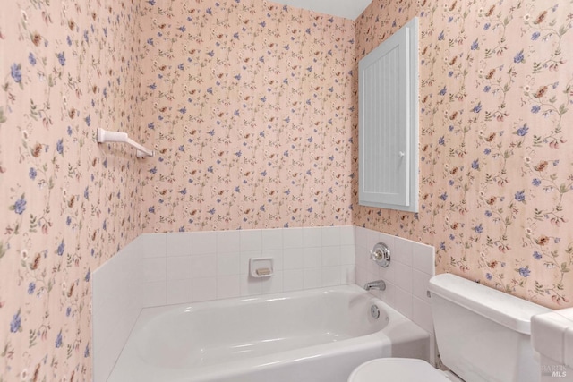 full bath with wallpapered walls, toilet, and a bath