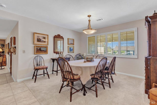 dining space featuring light tile patterned floors, visible vents, baseboards, and light carpet