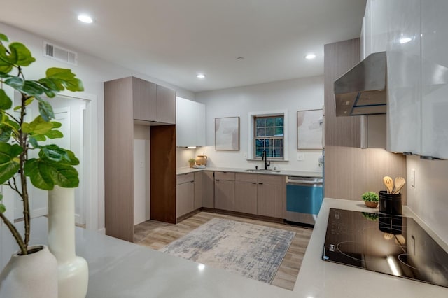 kitchen featuring visible vents, dishwashing machine, wall chimney exhaust hood, black electric cooktop, and a sink