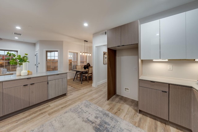 kitchen featuring light countertops, recessed lighting, visible vents, and light wood finished floors