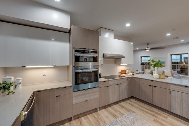 kitchen with visible vents, light wood-style floors, under cabinet range hood, double oven, and black electric stovetop