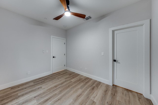 empty room with visible vents, ceiling fan, baseboards, and wood finished floors