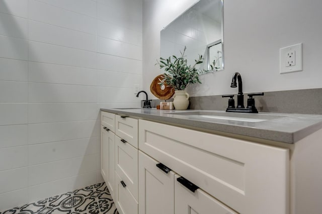 bathroom with double vanity, tile walls, and a sink