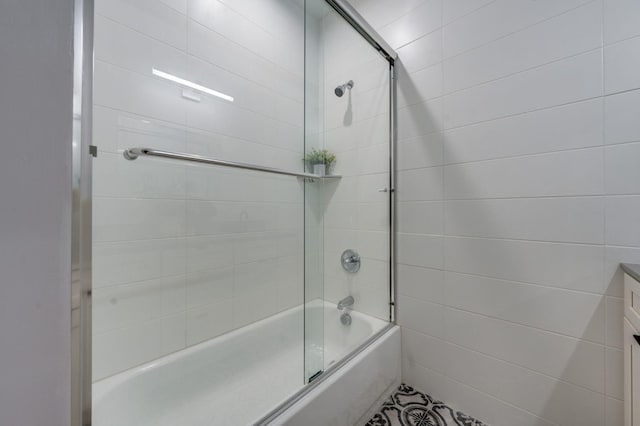 full bath featuring vanity and bath / shower combo with glass door