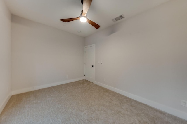 unfurnished room featuring light carpet, visible vents, baseboards, and a ceiling fan