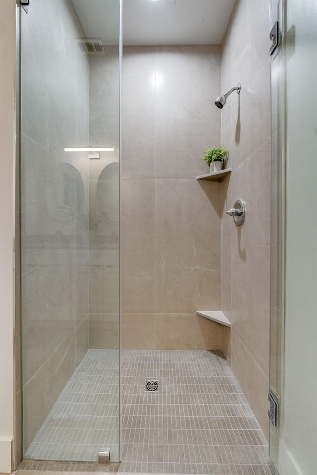 bathroom with a shower stall and visible vents