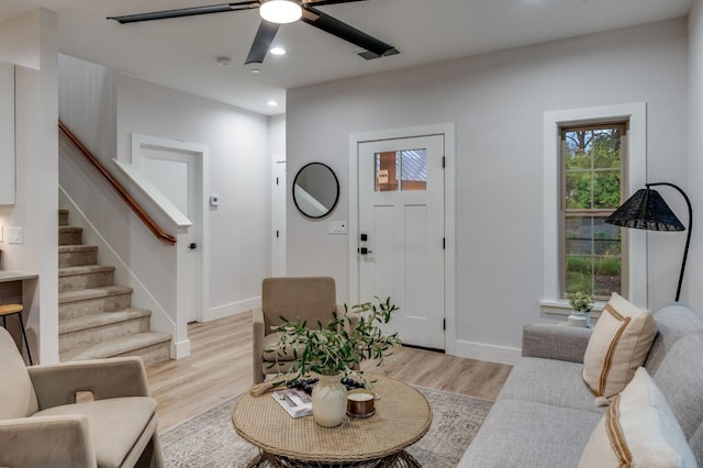 living room with recessed lighting, light wood-type flooring, baseboards, and stairs