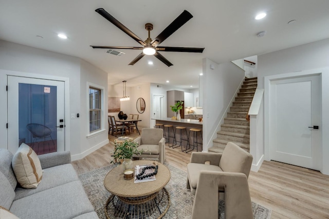 living room with stairway, recessed lighting, visible vents, and light wood finished floors