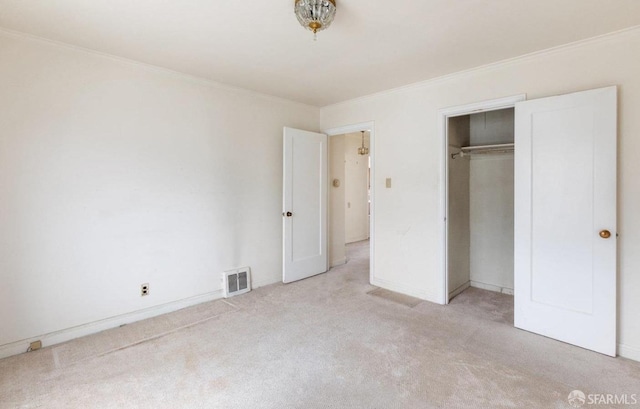 unfurnished bedroom featuring visible vents, ornamental molding, a closet, carpet floors, and baseboards