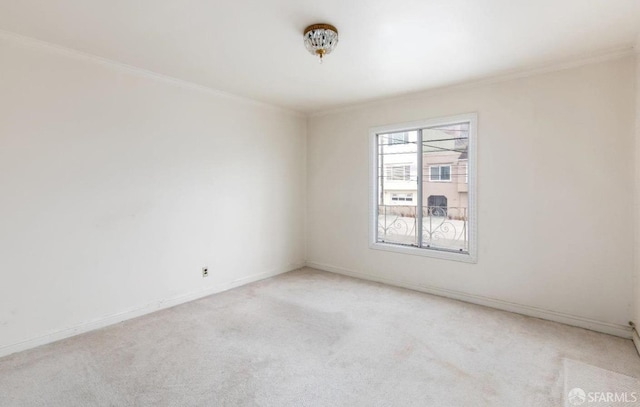 empty room featuring light carpet, crown molding, and baseboards