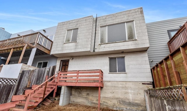 rear view of property with stairway and a deck