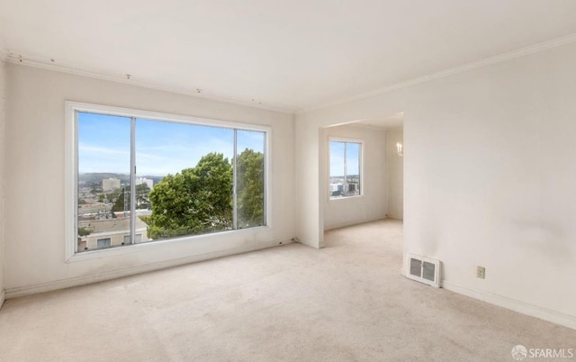 carpeted empty room featuring baseboards, visible vents, and ornamental molding