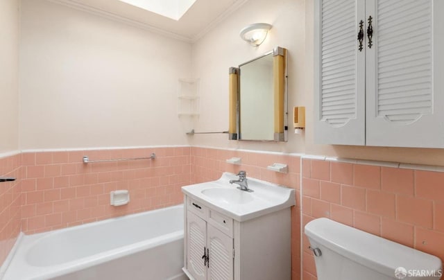 bathroom with toilet, a tub, a skylight, crown molding, and vanity