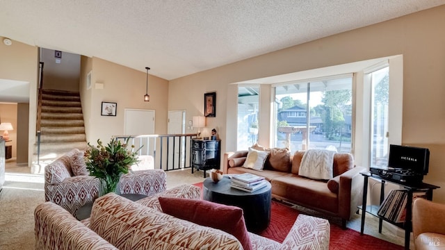 living room featuring lofted ceiling, stairway, carpet flooring, and a textured ceiling