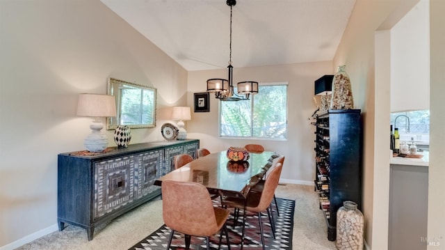 dining area with lofted ceiling, a notable chandelier, light colored carpet, and baseboards